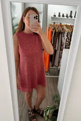 Vestido tejido sin mangas, color rojo con hilo lurex que le da un brillo sutil. Diseño de corte recto y holgado.