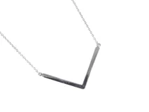 Collar plateado con dije en forma de V, de cadena fina con cierre de mosquetón.