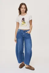 Jean de tiro medio y corte barrel con pierna amplia y ligeramente curva, estilo de cinco bolsillos en denim negro lavado.