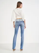 Pantalón de jean azul de corte recto, con cintura de color celeste y terminación desflecada.