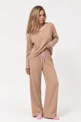 Pijama set compuesto por remera de manga larga y pantalón a rayas tostadas y blancas, con detalles en rosado en el cuello y lazo de ajuste en la cintura.