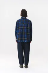 Camisa de corte holgado en color bordó con estampado de cuadros y monograma. Presenta cuello redondo con borde de puntilla, bolsillo frontal con detalle de puntilla, cierre frontal con botones y puños con terminación en puntilla.