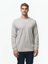 Remera de manga larga con cuello redondo, confeccionada en algodón de color gris claro. Presenta un diseño básico y versátil con puños acanalados y un pequeño detalle de logo cosido en el dobladillo.