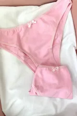 Bombacha básica tiro medio color rosa con moño blanco.