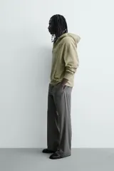 Sudadera de corte relajado color verde oliva con efecto lavado. Presenta capucha con abertura frontal, bolsillo tipo canguro, mangas largas con puños de rib y bajo con acabado irregular. Incluye estampado frontal con texto.