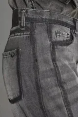 Pantalón de jean estilo oxford con diseño de paneles verticales en contraste y ruedo deshilachado.