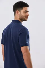 Remera polo lisa de piqué en color bordó, con cuello camisero, cierre frontal con botones y mangas cortas.