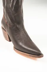 Botas texanas de cuero color marrón con bordados blancos en forma de estrellas y rayos.