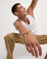 Pulsera dorada con eslabones grandes rectangulares y cierre de mosquetón.