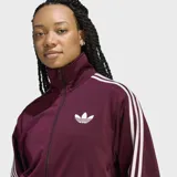 Campera deportiva Adidas modelo Firebird de corte holgado, color bordó con las icónicas tres rayas blancas en las mangas y logo del trébol bordado en el pecho. Cuenta con cierre frontal completo, cuello alto y puños acanalados.