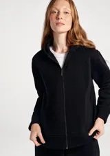 Campera con capucha y cierre frontal completo, de diseño liso y corte estándar, con bolsillos laterales.