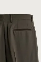 Pantalón de traje slim fit color marrón oscuro, confeccionado en tejido con viscosa, con bolsillos frontales, bolsillos traseros de doble vivo y raya marcada en las piernas.