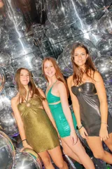 Vestido corto de satén color verde azulado (teal) con escote strapless y detalle de frunce central con argolla. Presenta tirantes finos que se atan al cuello y aberturas laterales en la cintura.