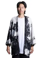Kimono blanco con estampado abstracto en negro, de mangas 3/4 y bolsillos frontales.