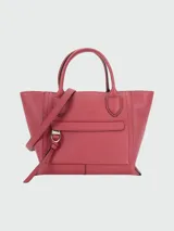 Cartera tipo tote de cuero granulado color rosado, con asas superiores y correa larga desmontable. Presenta un bolsillo exterior frontal con solapa y herrajes metálicos plateados.