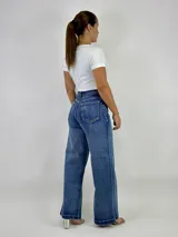 Pantalón de jean azul de tiro alto, corte wide leg y ruedo desflecado.