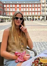 Pulsera dorada tipo brazalete rígido con perforaciones y pulsera dorada fina con dije de piedra blanca.