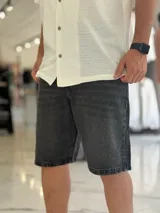 Bermuda de jean de corte oversize, en color negro con efecto gastado.