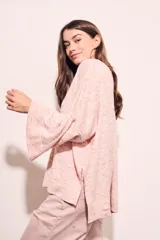 Sweater de punto con efecto jaspeado, de corte oversize, cuello redondo y mangas largas con terminación acampanada tipo volado.