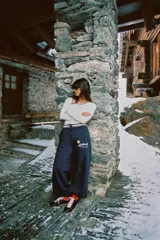 Pantalón de felpa azul marino con tiro alto, cintura elástica con cordón ajustable y diseño de pierna ancha. Presenta un estampado frontal con el logo de St. Moritz y un sol amarillo.