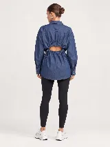 Camisa de denim azul con diseño oversize, cuello camisero, manga larga y cierre frontal de botones.