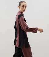 Polera de algodón con diseño bicolor en paneles verticales negros y bordó, cuello alto y tajos laterales.