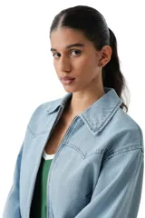 Campera de jean de corte corto con cierre frontal, cuello clásico y cintura elástica. Presenta mangas largas con puños abotonados y costuras tipo western en el pecho.