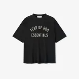 Camiseta negra de algodón con cuello redondo y corte ultra oversize. Estampado frontal con el texto "FEAR OF GOD ESSENTIALS" en color crema.