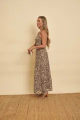 Vestido midi marrón con estampado paisley y floral, de tirantes finos, con aberturas en la cintura (cut-out) y diseño de corpiño estructurado.