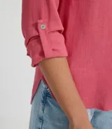 Camisa de manga larga confeccionada en mezcla de viscosa y lino, con cuello tipo padre, escote en V y cierre frontal con botones. Presenta un diseño con dobladillo tipo mullet, siendo más largo en la parte posterior.