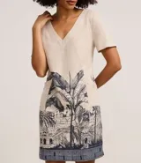 Vestido corto tipo t-shirt color beige, confeccionado en viscolino, con escote en V y mangas cortas. Presenta una estampa de arco de lapa en la falda.