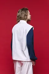 Chaleco sastrero blanco de corte relajado, con hombros amplios, solapa tipo smoking y cierre frontal de un botón. Cuenta con bolsillos con solapa en los laterales.