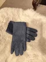 Guantes de cuero marrón oscuro, cortados y cosidos a mano, con detalle de borde de piel sintética en las muñecas.