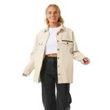 Campera color beige de corte recto, con cuello camisero, cierre frontal con botones a presión y bolsillos con solapa en el pecho. Presenta bordados decorativos en el frente y la espalda.