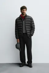 Cazadora acolchada de corte regular fit, confeccionada en tejido técnico repelente al agua. Presenta cuello subido, cierre frontal de cremallera, bolsillos laterales de vivo y puños con elástico.