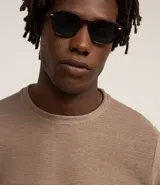 Remera de manga larga con cuello redondo y textura acanalada, confeccionada en una mezcla de poliéster y algodón.