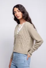Cardigan color beige con trama de punto trenzado, cuello en V y cierre frontal con botones.