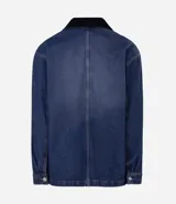Campera de jean de corte oversized, con cuello de terciopelo, cierre frontal por botones y bolsillos grandes aplicados en el frente.