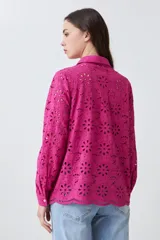 Camisa fucsia de broderie con cuello clásico, cierre frontal con botones y mangas largas.