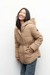 Campera puffer color tostado con capucha, cierre frontal con botones a presión y bolsillos laterales. Presenta diseño acolchado, puños elásticos y ajuste en la cintura.