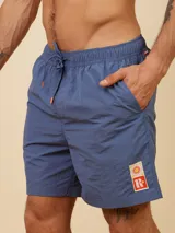 Short de baño de color liso con cintura elástica ajustable mediante cordón y detalle de parche con logo en la parte inferior.
