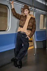 Campera tipo bomber de corte cropped, con estampado de cuadros en tonos marrones. Presenta cuello de piel sintética, cierre frontal con cremallera, bolsillos frontales con solapa y puños y cintura de tejido elástico acanalado.