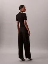 Pantalón de pierna ancha color negro, confeccionado en sarga de algodón, con cintura elástica y diseño moderno.