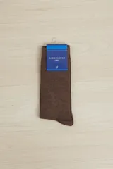 Par de medias de vestir color marrón oscuro, con textura de punto fino. Vienen empaquetadas con una etiqueta azul de la marca Harrington Label.