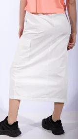 Falda midi color negro, de corte recto, con bolsillos cargo laterales y abertura frontal.