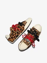 Championes Converse Chuck Taylor Low con exterior de pelo con estampado animal print de leopardo, puntera de goma blanca, y doble juego de cordones en color rojo jaspeado y negro.