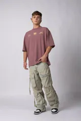 Jean baggy de corte holgado con múltiples bolsillos cargo frontales con cierre metálico. Presenta un acabado lavado, tiro medio y tiras de ajuste en la botamanga.