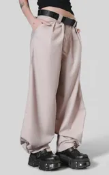 Pantalón sastrero de corte oversize en color beige, confeccionado en tejido premium con estructura. Presenta pinzas frontales profundas que aportan volumen, cintura ancha con presillas, bolsillos laterales y bolsillos traseros tipo ojal.