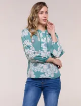 Blusa de gasa texturizada color verde con estampado floral blanco, cuello mao con escote en V y botones frontales. Cuenta con mangas 3/4 abullonadas y detalles de puntilla calada en el pecho.
