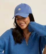 Gorra de sarga celeste con ala curva y ajuste posterior. Presenta un delicado bordado frontal en forma de margarita con centro amarillo.